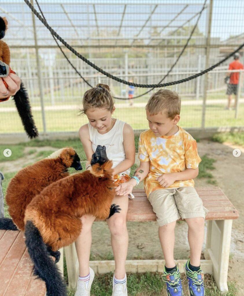 Little kids feeding ruffed lemurs