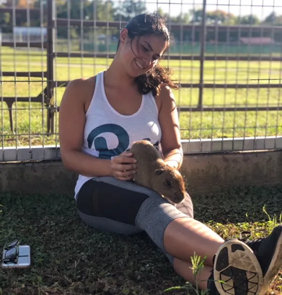 Intern at Sharkarosa Zoo petting an animal in her lap.